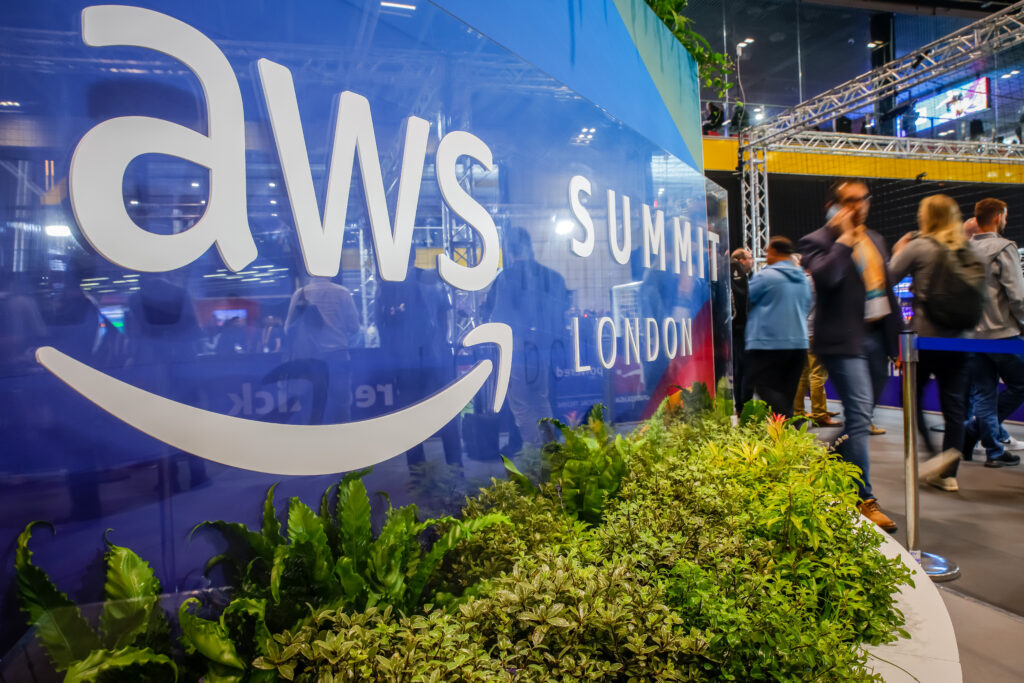 Indoor image of blue sign with grass below it | AWS Summit London
