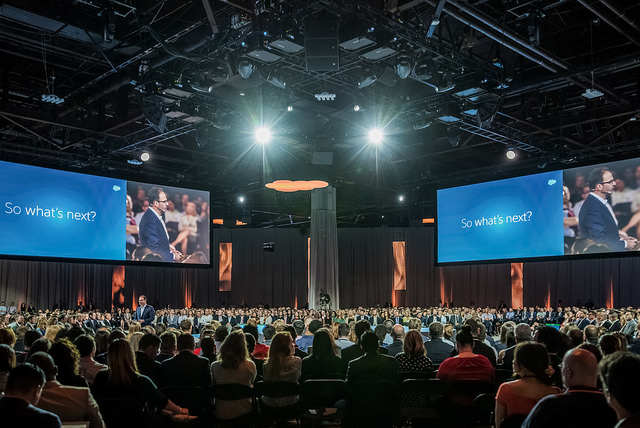 Full conference hall with big screens asking "what's next?" | Salesforce Connections