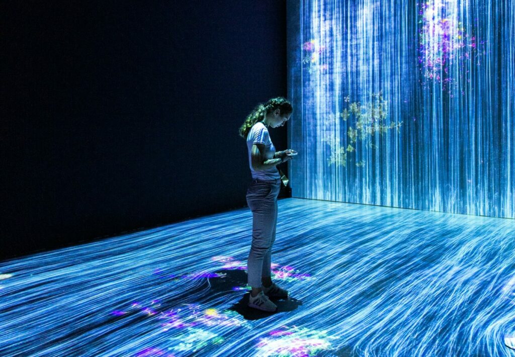 image of interactive art exhibition with person in the middle of the immersive blue and purple room | Guided Learning