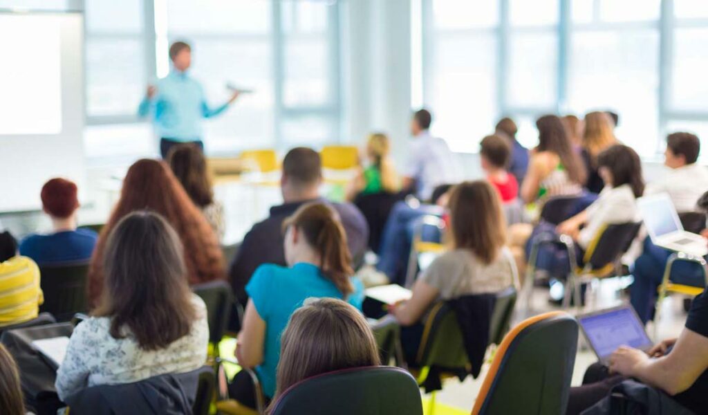 blurred image of a full classroom, from the perspective of a student | de Novo MATA