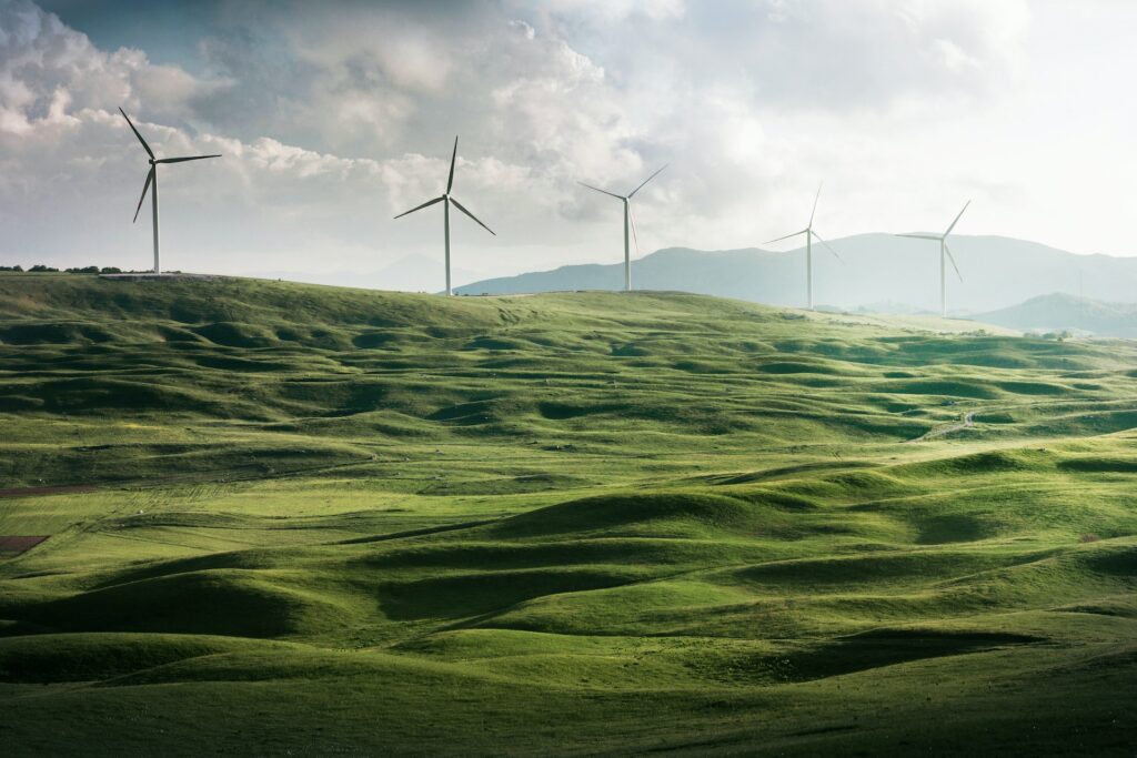 image of wind turbines on rolling green hills | sustainability initiative