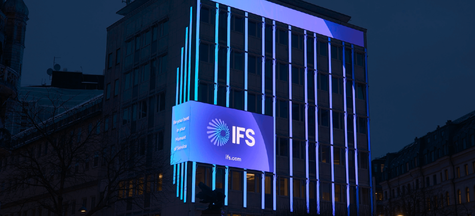 IFS's logo in purple on the outside wall of a building | IFS with key AI acquisition and flurry of partnerships