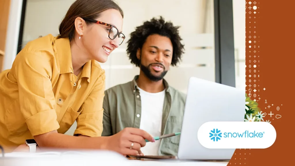 Two people smiling and looking at a laptop screen | Salesforce and Snowflake BYOL