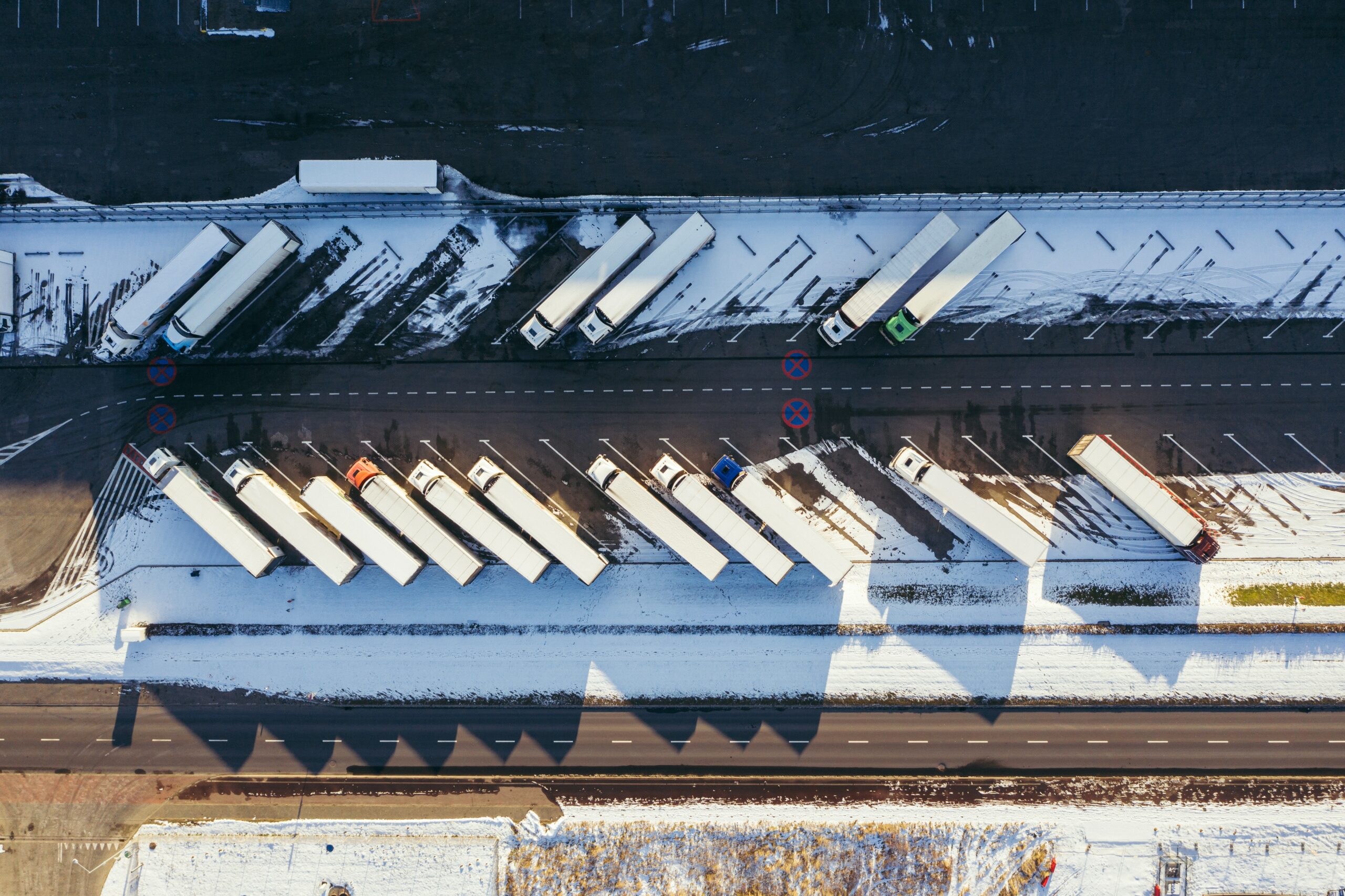 Top-down view of trucks in a depot, half covered in snow | Samsara privacy