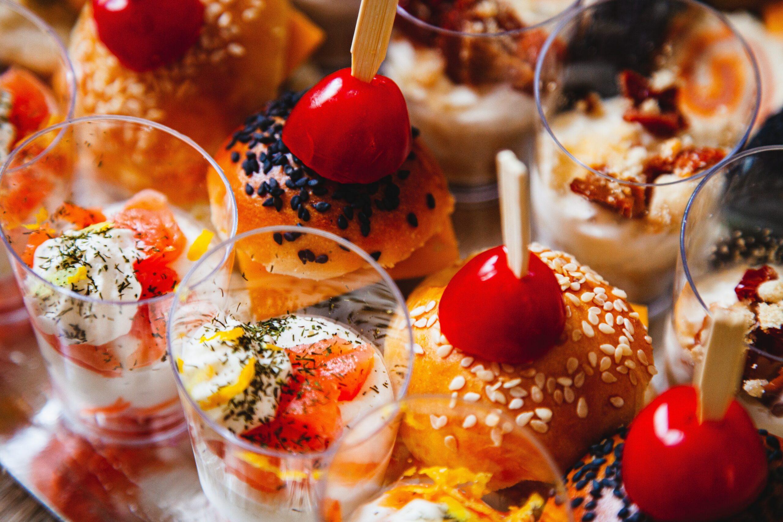 Top down view of several small, cakes, sliders and party favours | Daudruy Infor