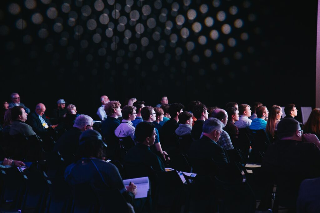View of an audience sitting at a conference in a dark room | Celosphere Celonis