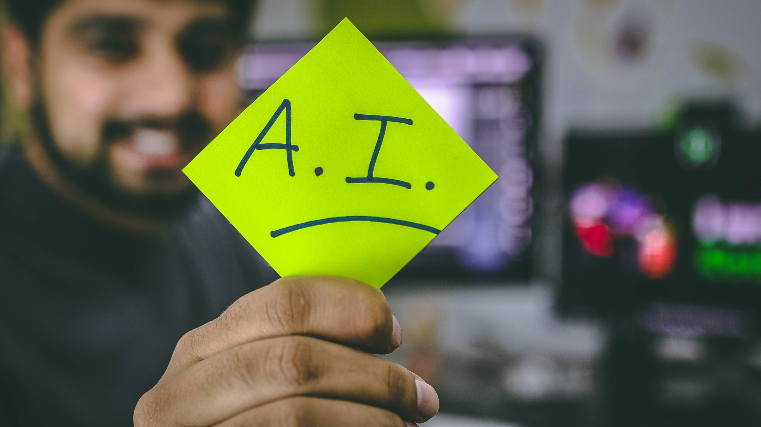a man holding a sticky note with AI written on it | Will the UK’s AI safety summit actually make an impact?