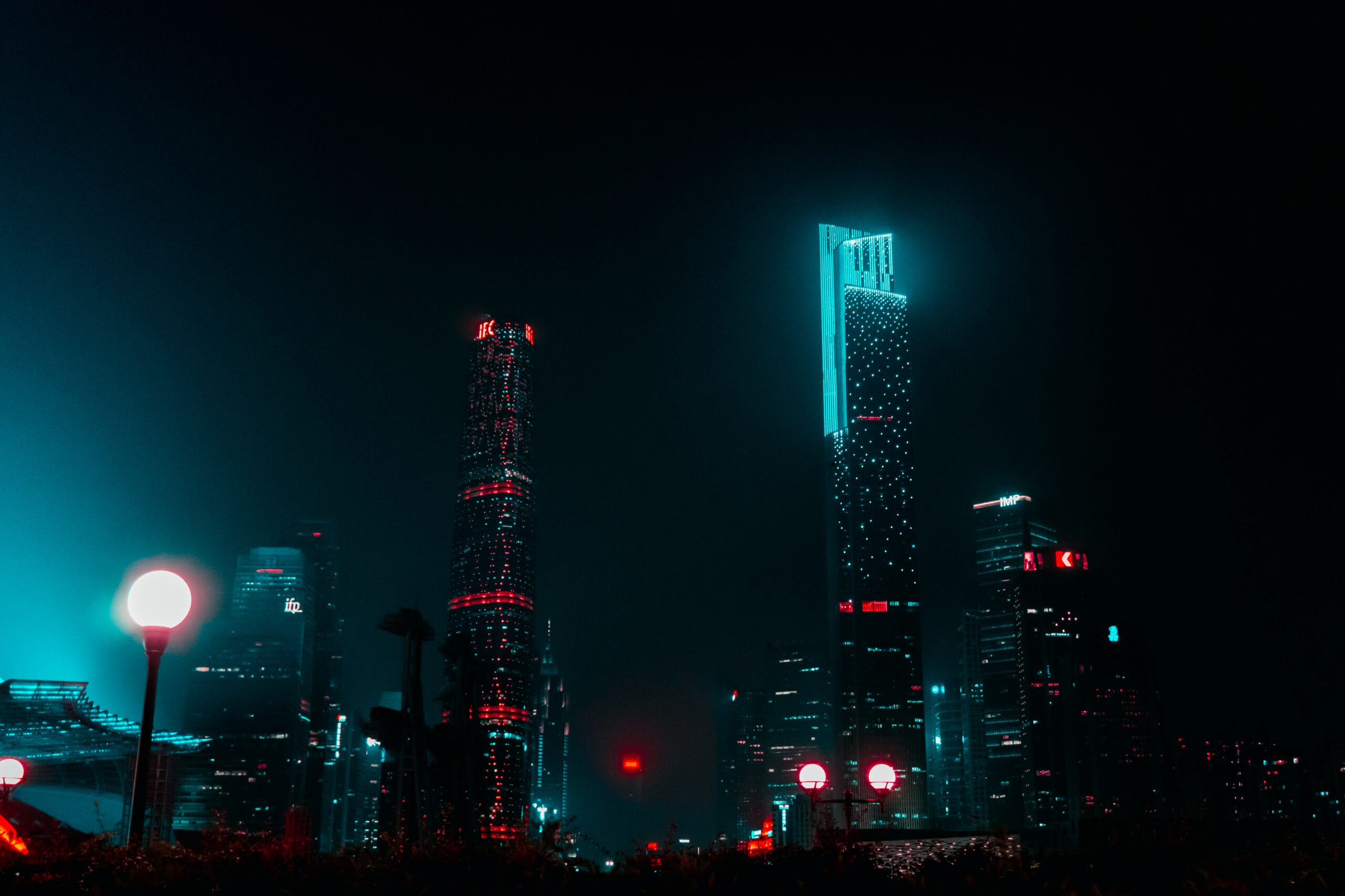 Futuristic city scape with bright, neon lights highlighting tall buildings during the night | Inoapps modernization