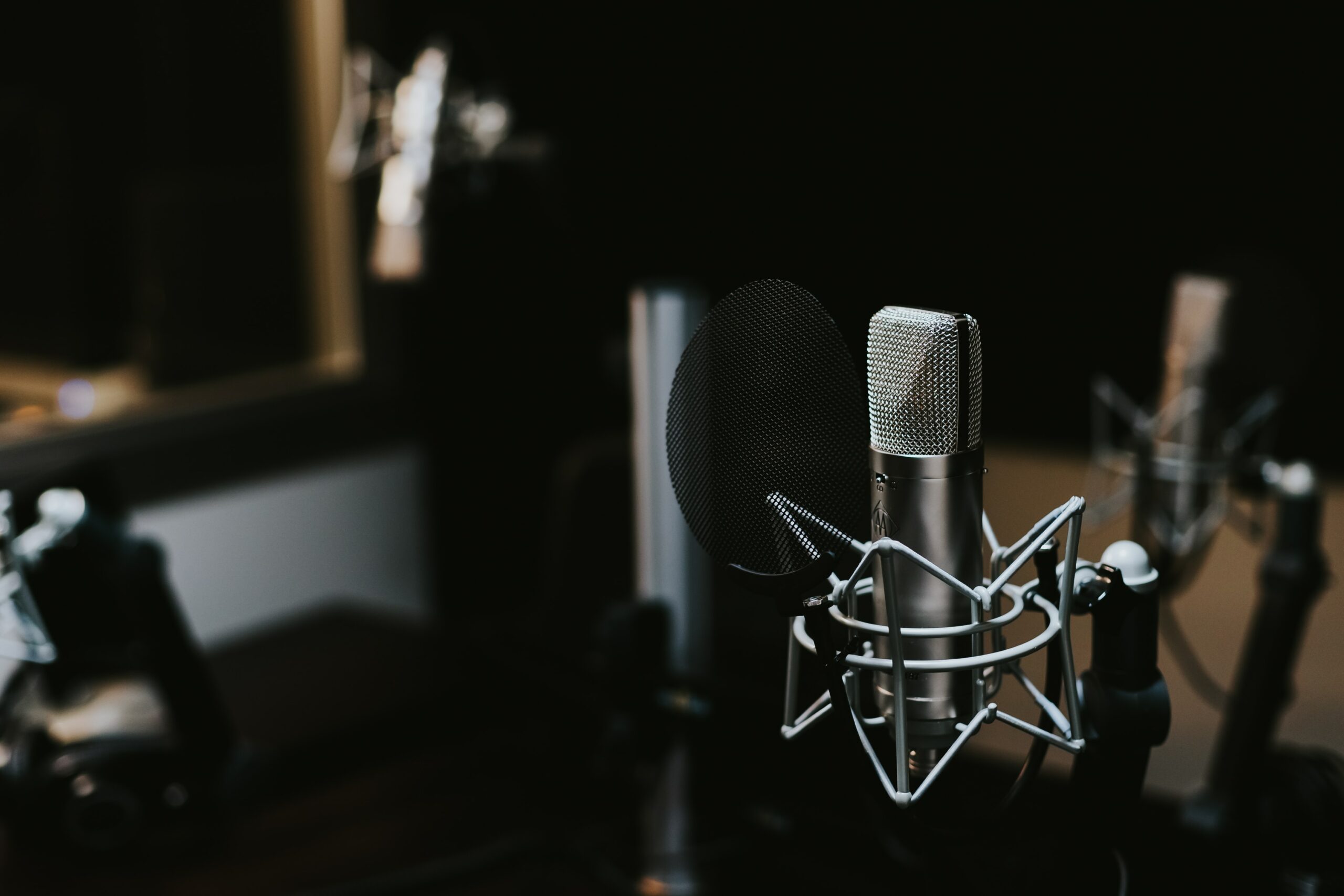 Darkened recording room with an expensive-looking microphone taking focus | HCA HPE