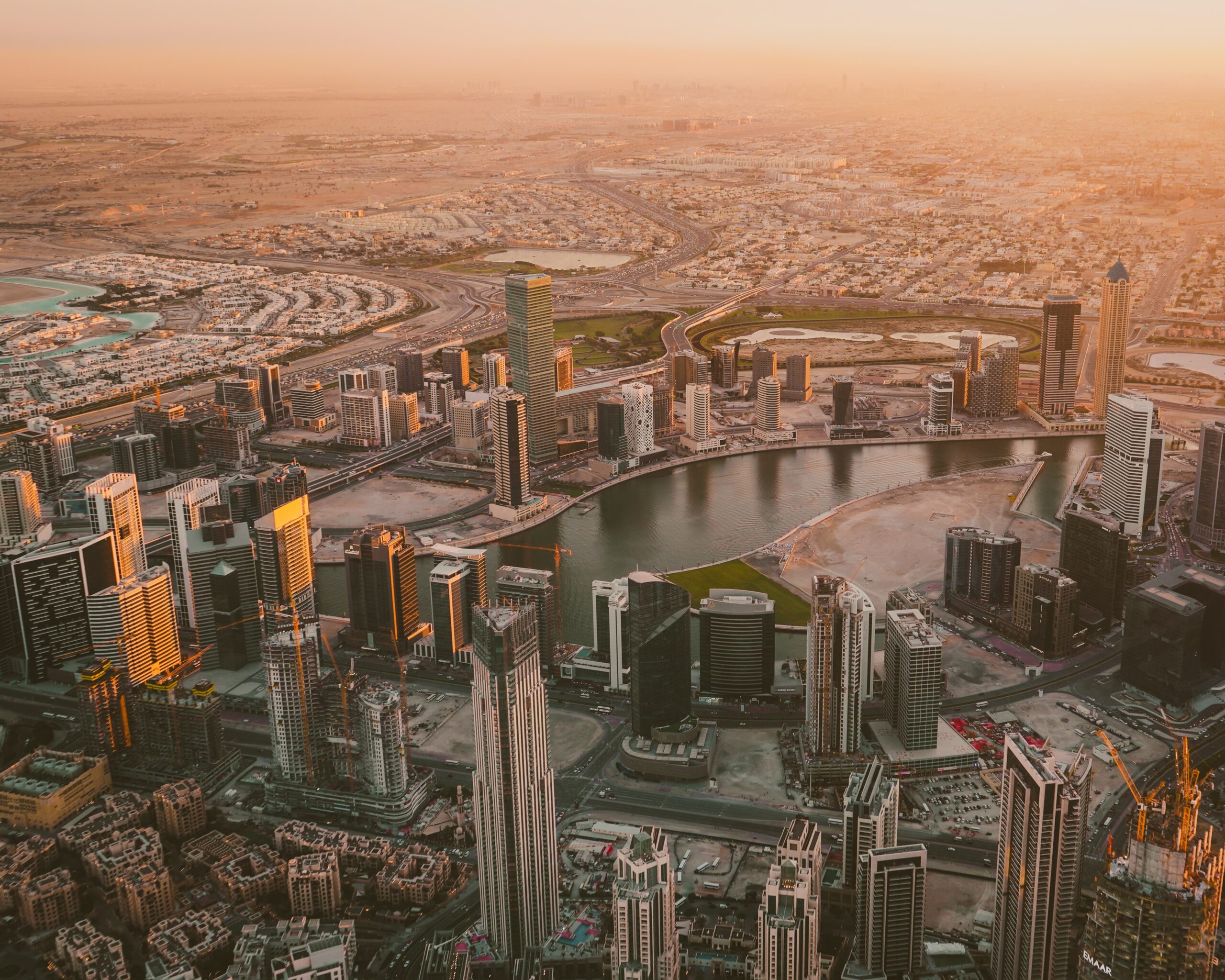 Top-down view of a city skyline, showing multiple skyscrapers, a river running-through and a lovely sunset | Boomi