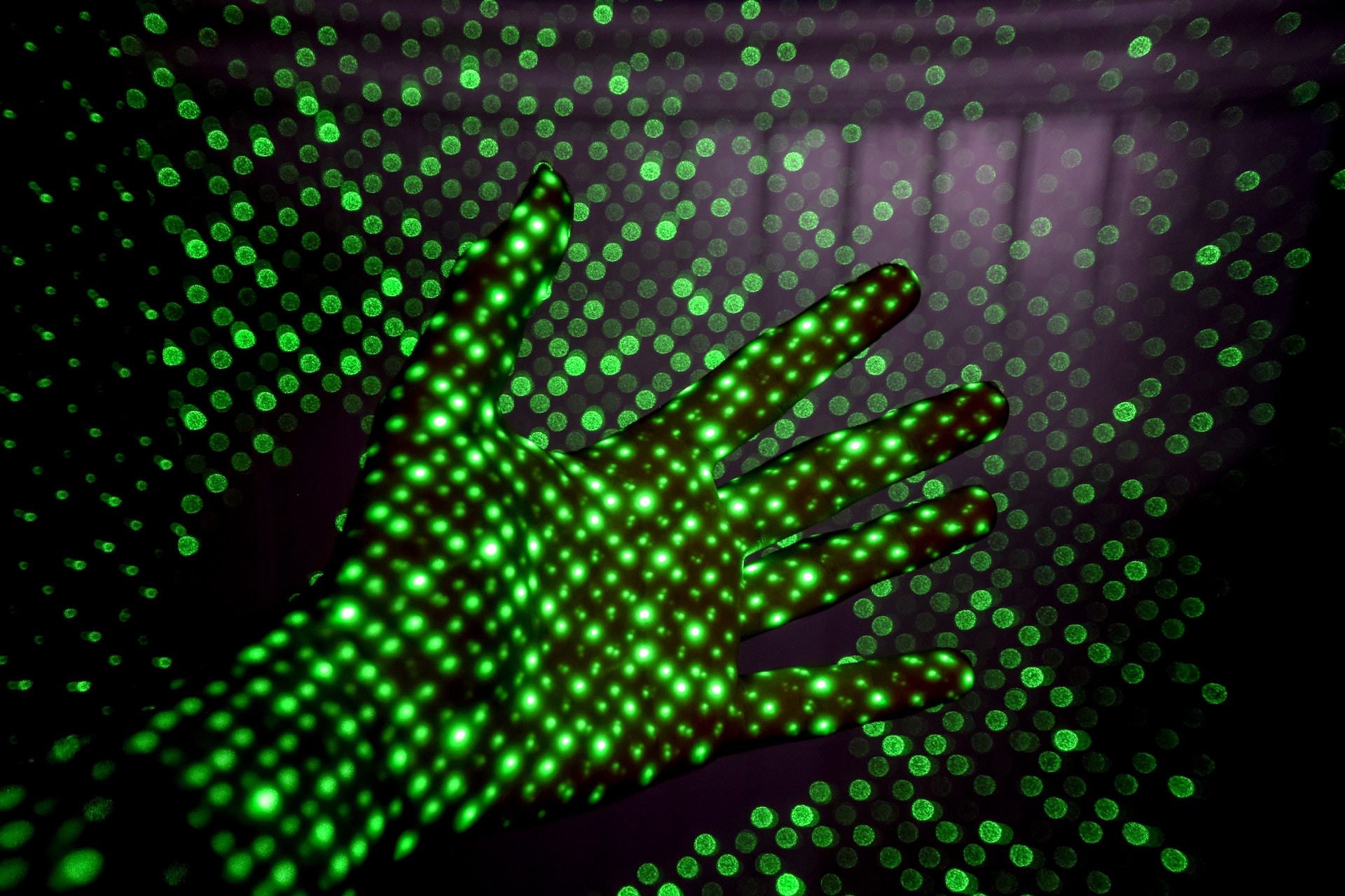 image of hand and projection of green dots | Atos