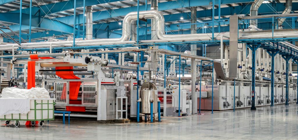 Landscape view of a factory with a lot of complex pipes and machinery throughout | smart factory Infor