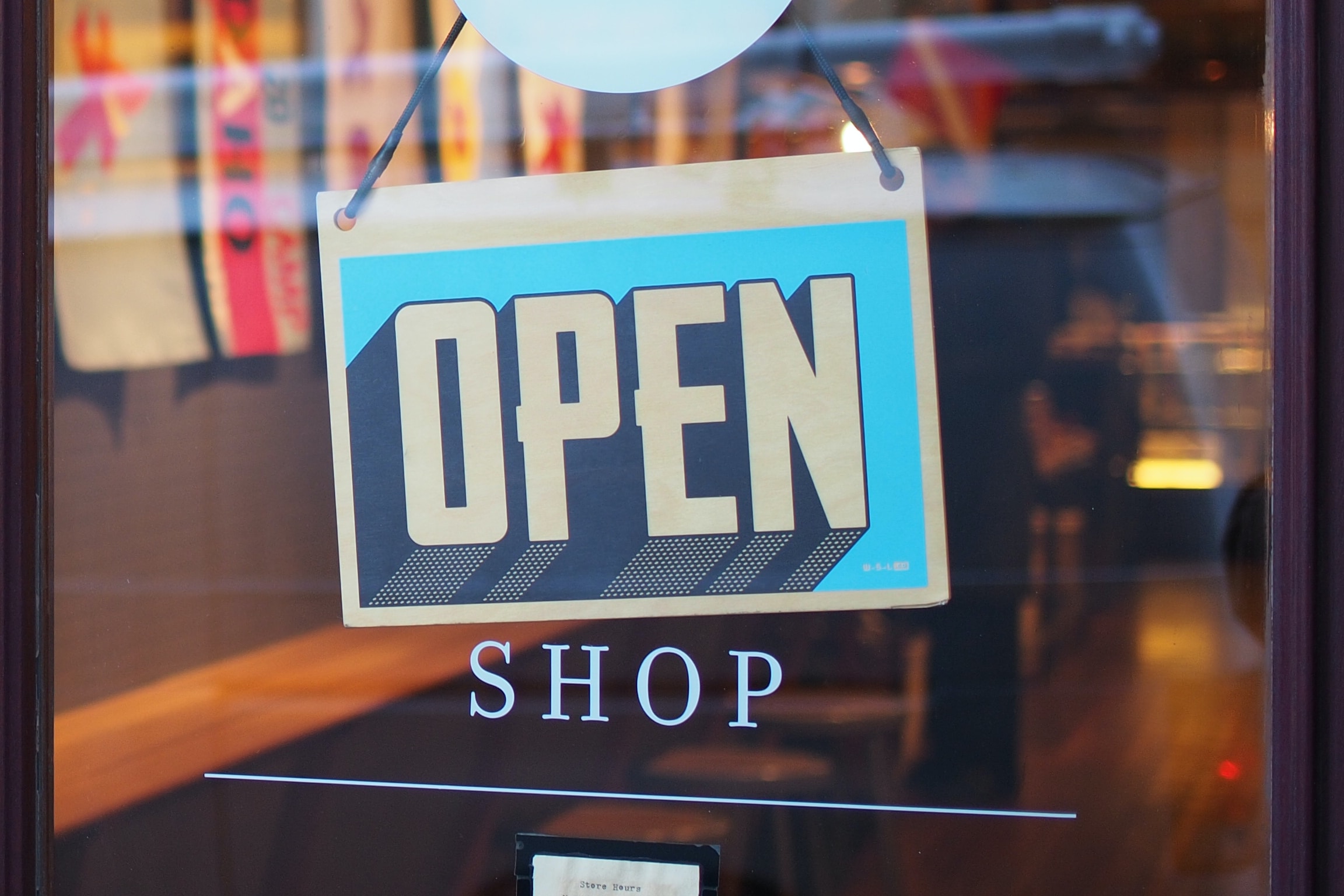 A close up of a shop sign, showing 'open' in a large font | Coop Danmark KPS
