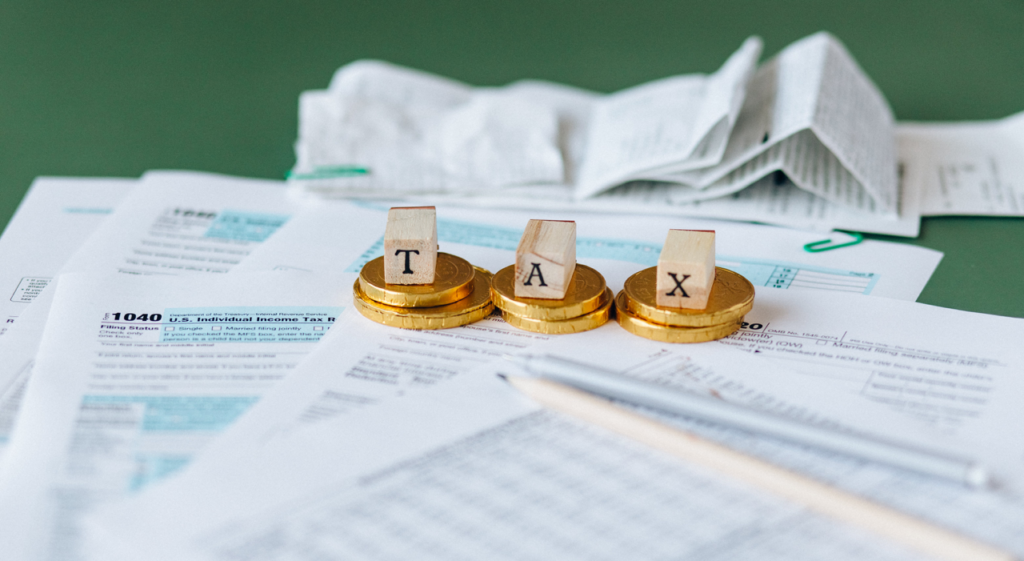 tax forms with coins and letters t a x
