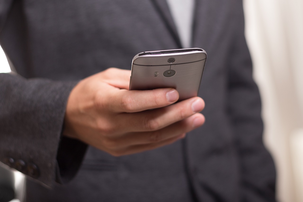 a person wearing a suit holding a smartphone
