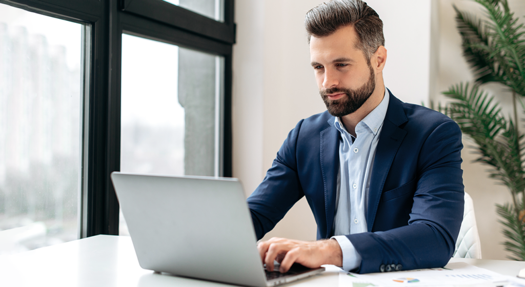 man at desk working on laptop