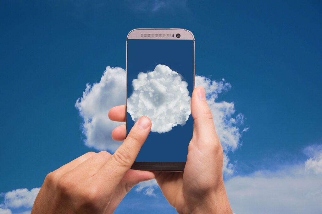 a person taking a picture of a cloud with a smartphone