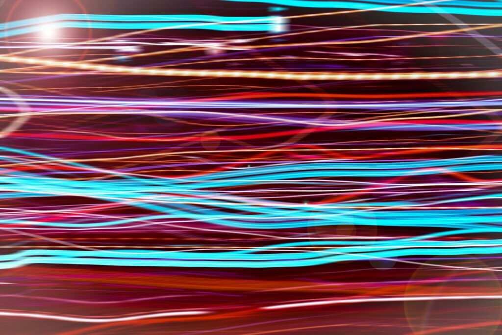 Several different fibre wires running over each other, lit in several different neon colours | Oracle cloud Inoapps