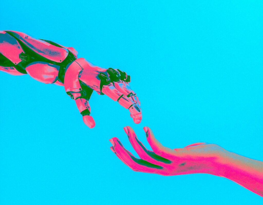 image of robot hand reaching out to human hand with blue background | AI Summit