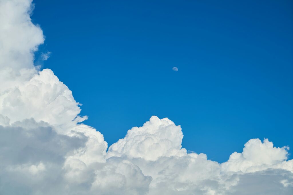A lovely blue sky framed by puffy white clouds creeping in from the left hand corner | cloud InsightSoftware