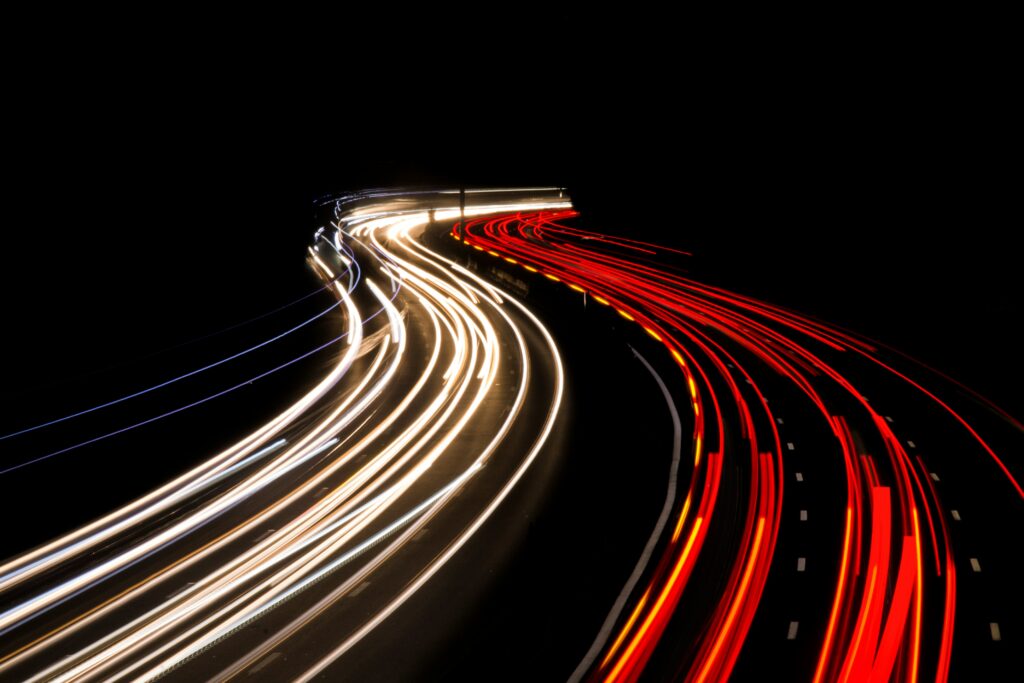 Timelapsed light trails from a road at night, showing red and white trails of light | migrating Accelalpha