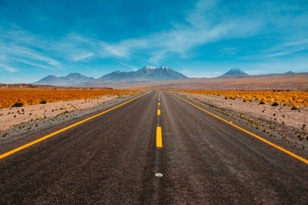 photograph of a road in a desert leading to mountains during sunny day; digital transformation concept