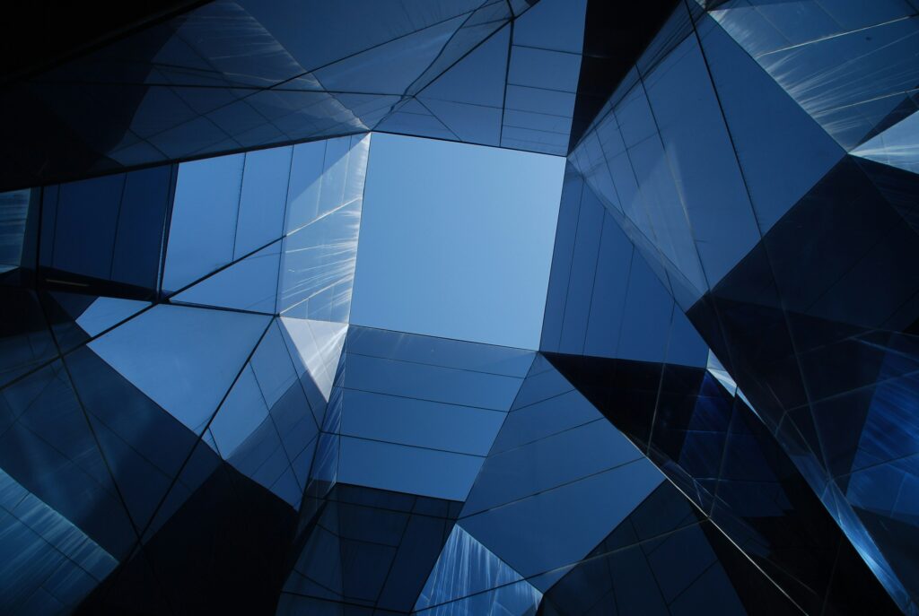A mirrored view upwards towards a blue square of sky | tax Vertex