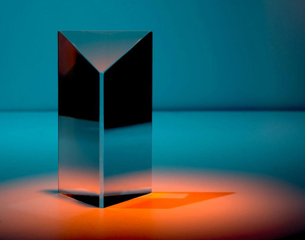 A black, reflective prism under an orange spotlight in a dark blue room | Process Intelligence Celonis