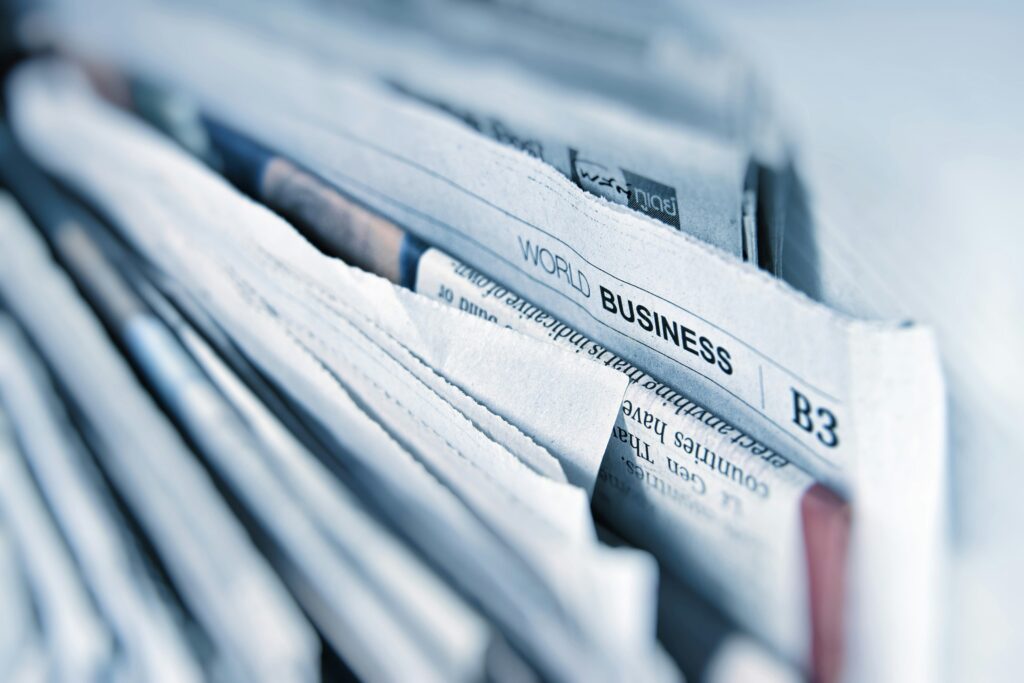 Close up image of some corners of newspapers with 'world business' having particular focus | liquidity Kyriba