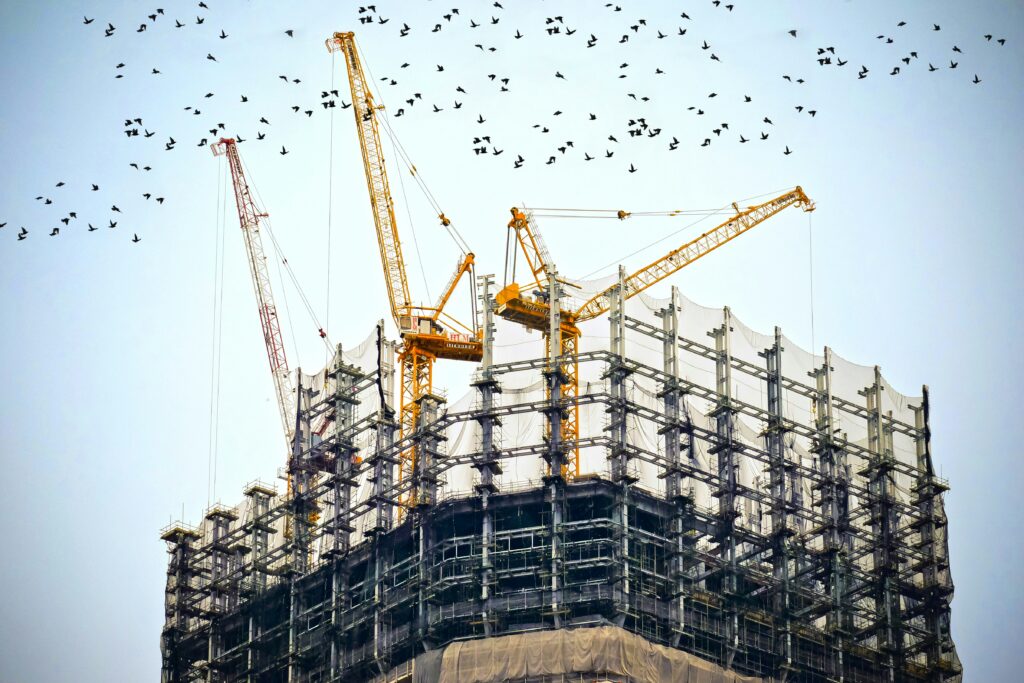 construction building with cranes and birds flying in the sky | Sage launches native-cloud Construction Suite for Specialty Contractors