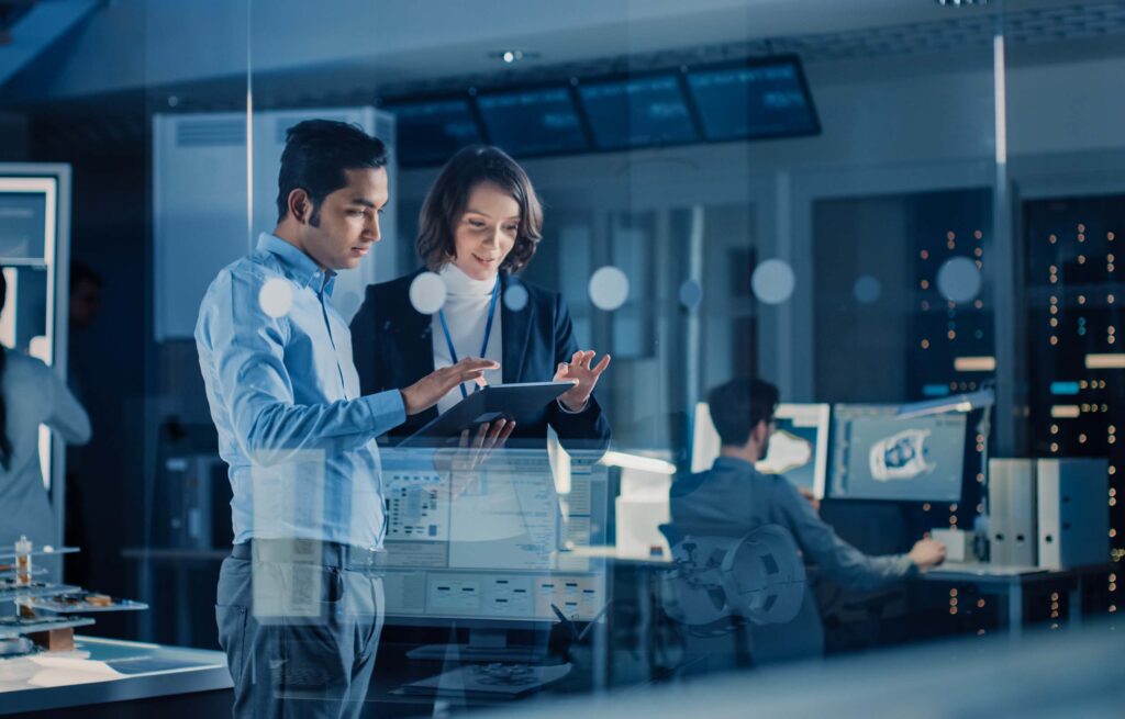 A man and a woman tapping at a tablet while standing in a glass surrounded office | third-party support