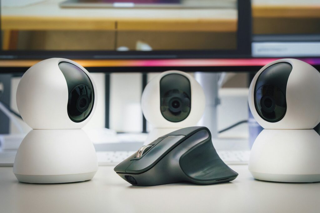 3 cameras surrounding a futuristic looking computer mouse on a white desk | Delinea