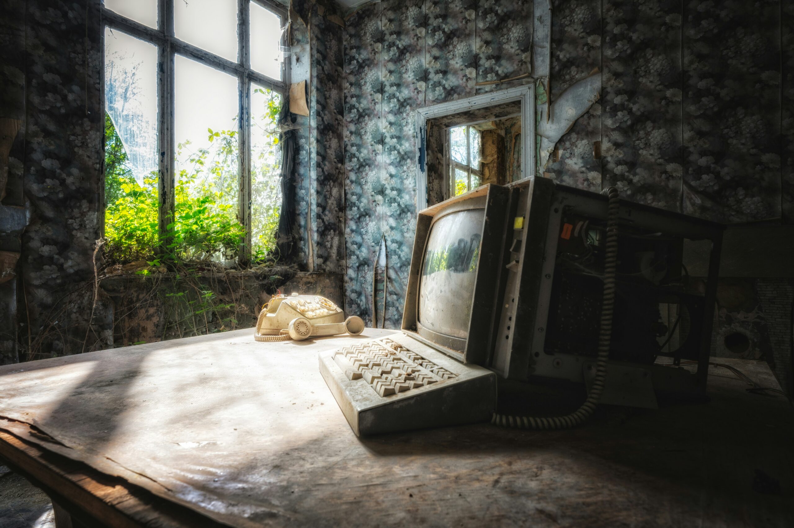 Image of a dusty computer in an old house, plants and sunshine visible through window | ERP Nextworld