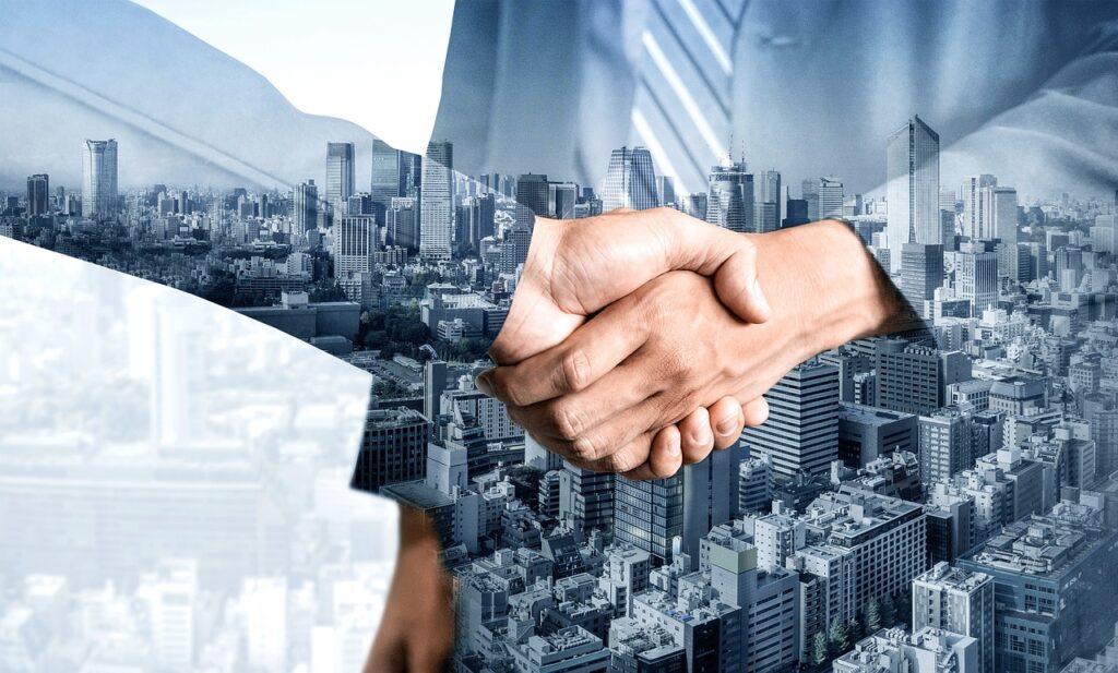 two hands in a handshake with tall urban buildings in the background | LTIMindtree and SNP launch MELD: Platform for acquisitions & divestitures data management for SAP customers