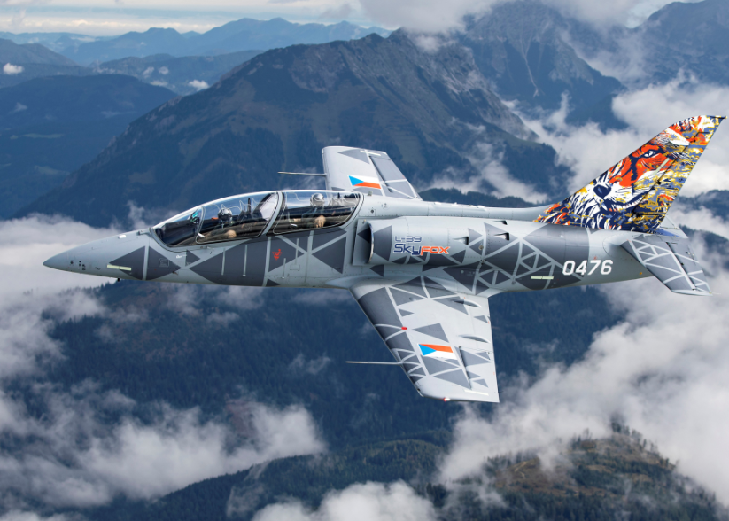 photo of the Czech Aero Vodochody plane flying in the sky with mountains and clouds in the background | IFS Cloud x Aero