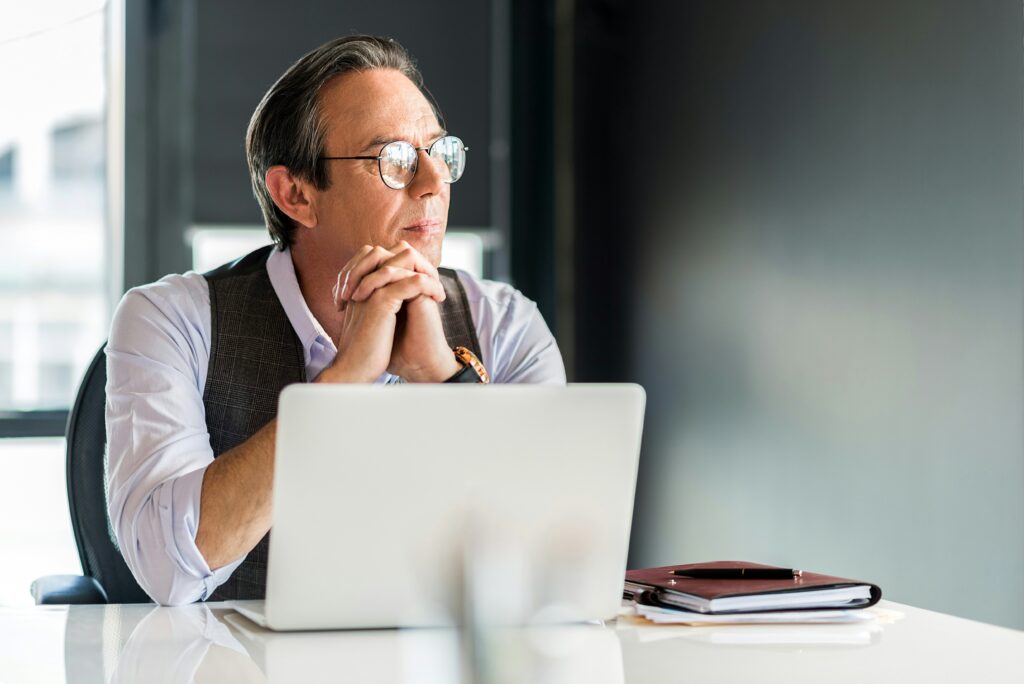 a man sitting at a desk behind a laptop | Veolia’s invoice processing rehaul