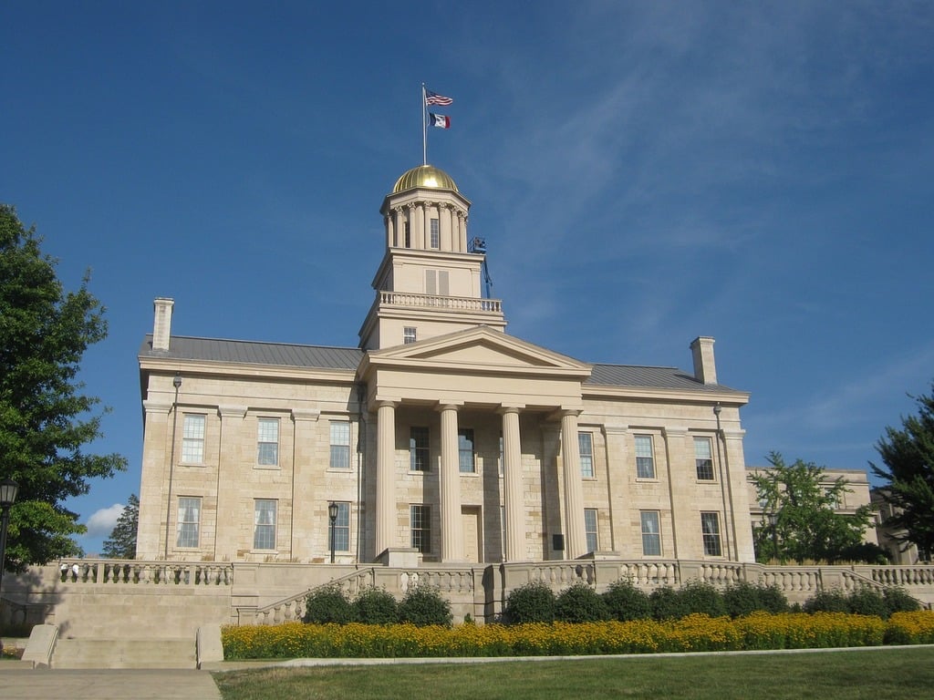 Old capitol iowa city iowa building. A large building with a flag on top of it | Tyler Technologies partners with state of Iowa to modernize public safety systems