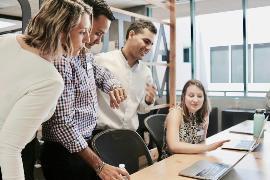 four office workers smiling while interacting