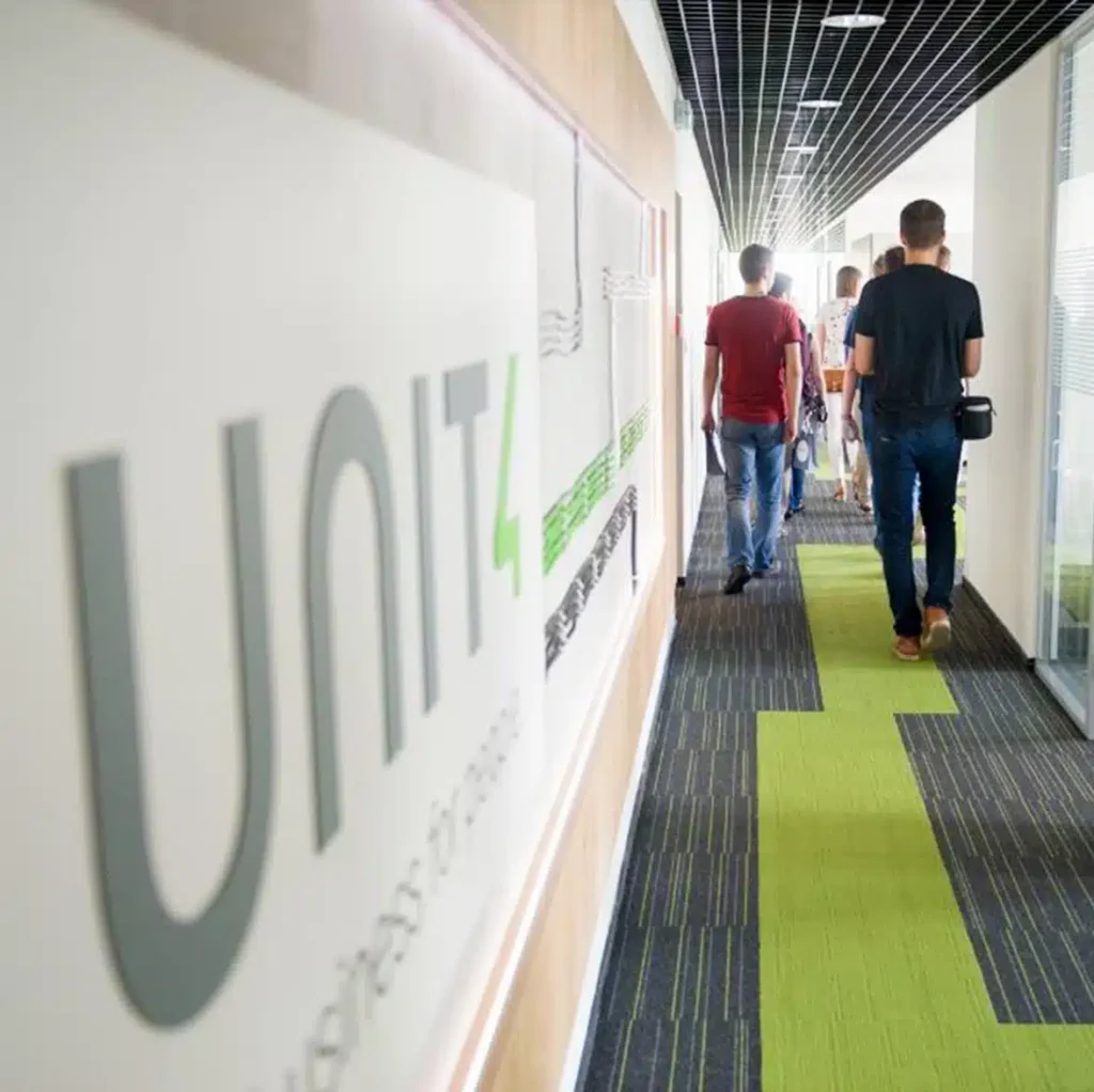 Unit4 office corridor with employees who developed Financials by Coda walking signage.