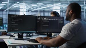 Security analyst monitoring code and identity access controls across multiple screens following accelerated AI-driven breach activity