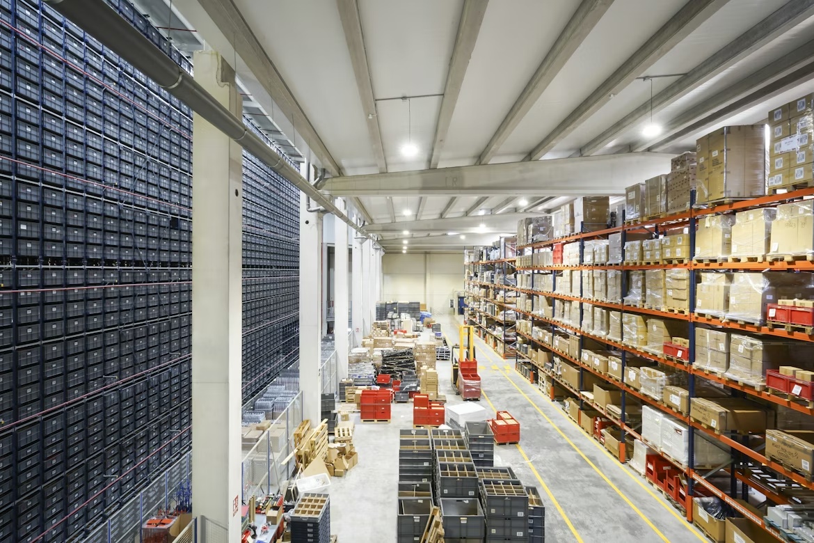 Large warehouse with organized rows of boxes representing structured procurement workflows and supply chain coordination.