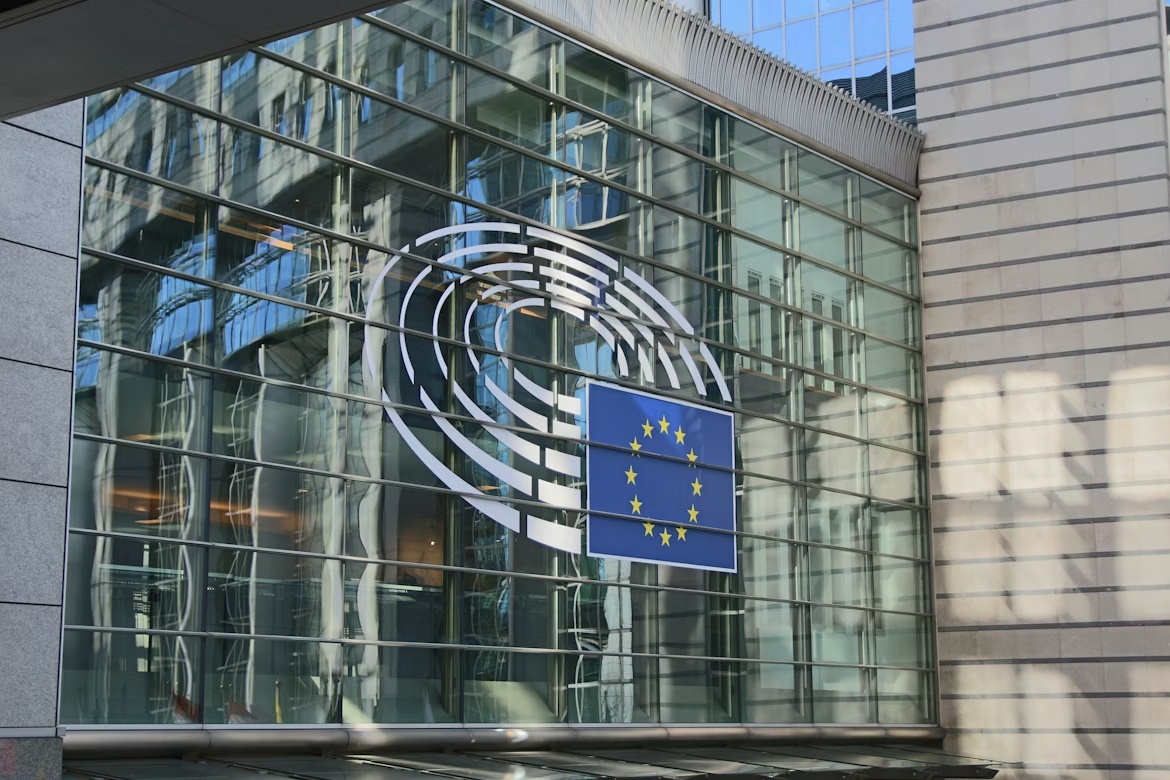 EU flag displayed on the glass exterior of the European Parliament building, representing ERP governance questions around the EU AI Act delay.