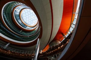 Circular glass atrium with layered architecture and a hexagonal skylight, illustrating complexity across modern ERP and enterprise systems.