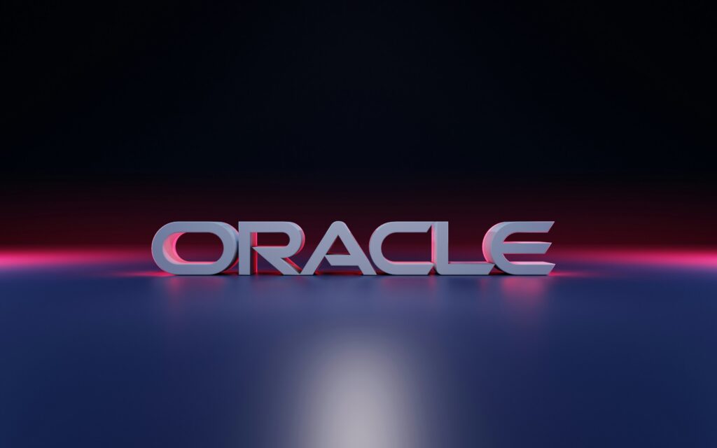Oracle logo illuminated by pink and blue lighting against a dark background.