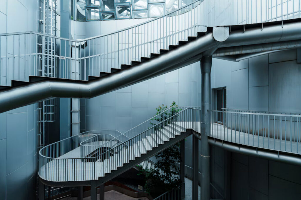 Interconnected metal staircases and walkways inside a modern building, illustrating access paths and security risks in SAP systems.