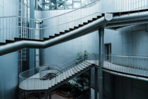 Interconnected metal staircases and walkways inside a modern building, illustrating access paths and security risks in SAP systems.