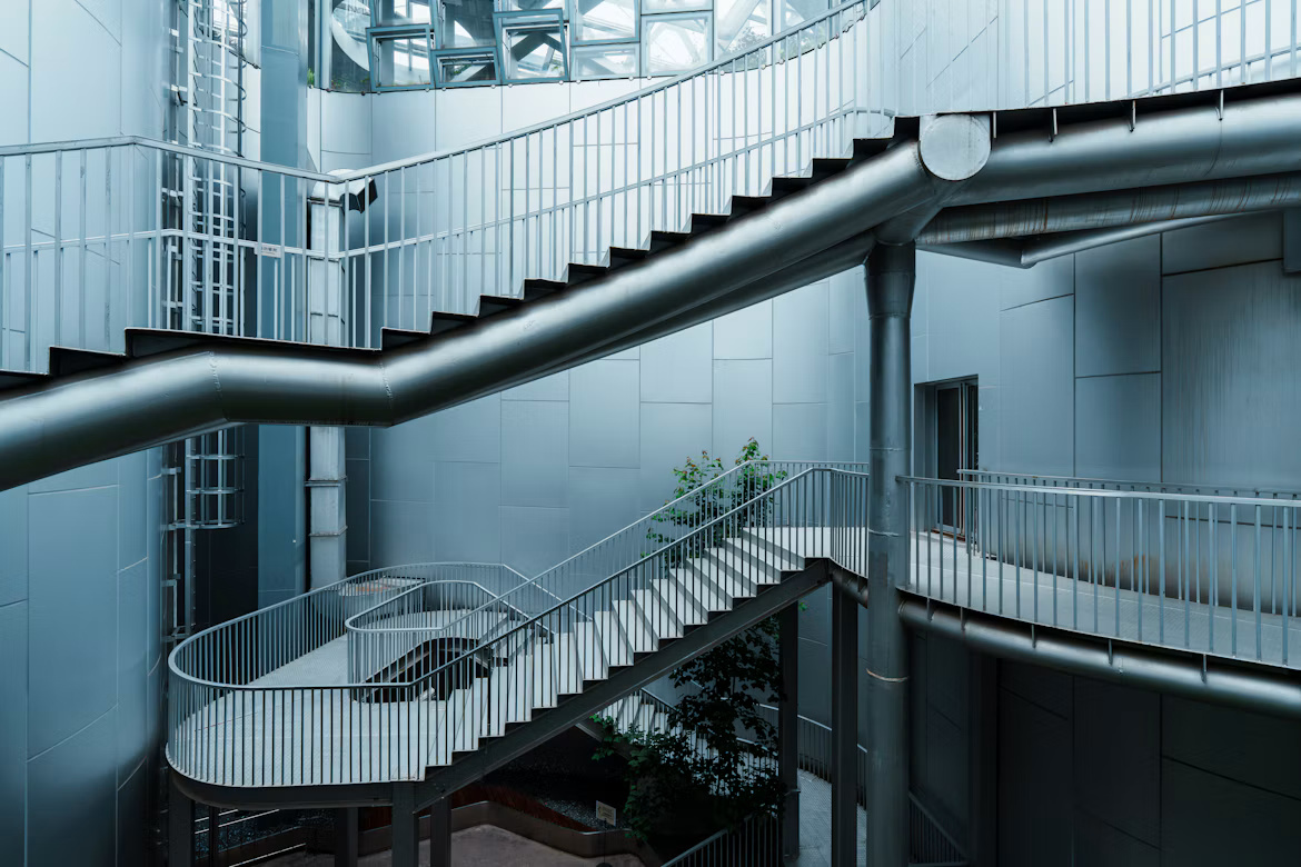 Interconnected metal staircases and walkways inside a modern building, illustrating access paths and security risks in SAP systems.